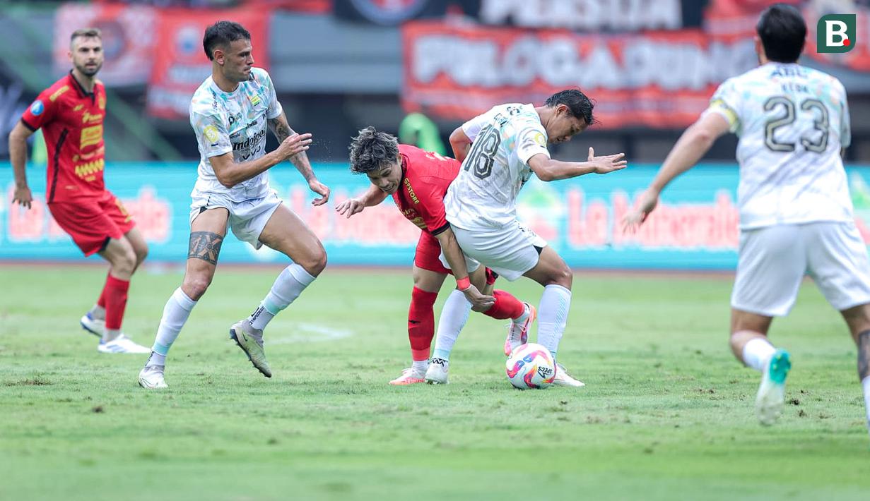 Pemain Persija Jakarta, Ryo Matsumura (tengah kiri) berebut bola dengan pemain Persib Bandung, Adam Alis dalam laga lanjutan BRI Liga 1 2024/2025 di Stadion Patriot Candrabhaga, Bekasi, Minggu (16/02/2025). (Bola.com/M Iqbal Ichsan)