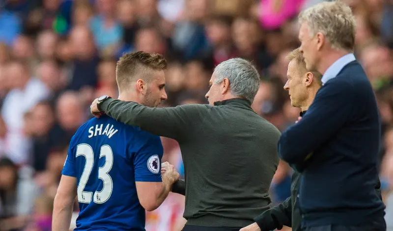 Luke Shaw mendapat ucapan selamat dari Jose Mourinho ketika diganti pada laga melawan Sunderland, Minggu (9/4/2017). (EPA/Peter Powell)