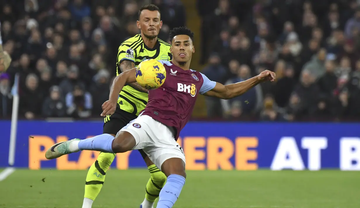 Striker Aston Villa, Ollie Watkins (depan) melepaskan tendangan di depan bek Arsenal, Ben White pada laga pekan ke-16 Liga Inggris 2023/2024 di Villa Park, Birmingham, Minggu (10/12/2023) dini hari WIB. (AP Photo/Rui Vieira)