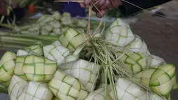 Pedagang membawa kulit ketupat untuk dijual di kawasan Bintaro, Jakarta, Sabtu (10/8/2019). Menjelang Idul Adha, para pedagang menjual kulit ketupat dengan harga sekitar Rp 8 ribu per sepuluh buah tergantung ukuran. (Liputan6.com/Herman Zakharia)