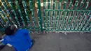 Silva Cossa, seorang pengurus mendongak ketika mengikat pita ke pagar gereja St James Presbyterian di Bedford Gardens, Johannesburg, Rabu (29/7/2020). Pita tersebut mewakili warga Afrika Selatan yang meninggal akibat virus corona COVID-19. (AP Photo/Themba Hadebe)