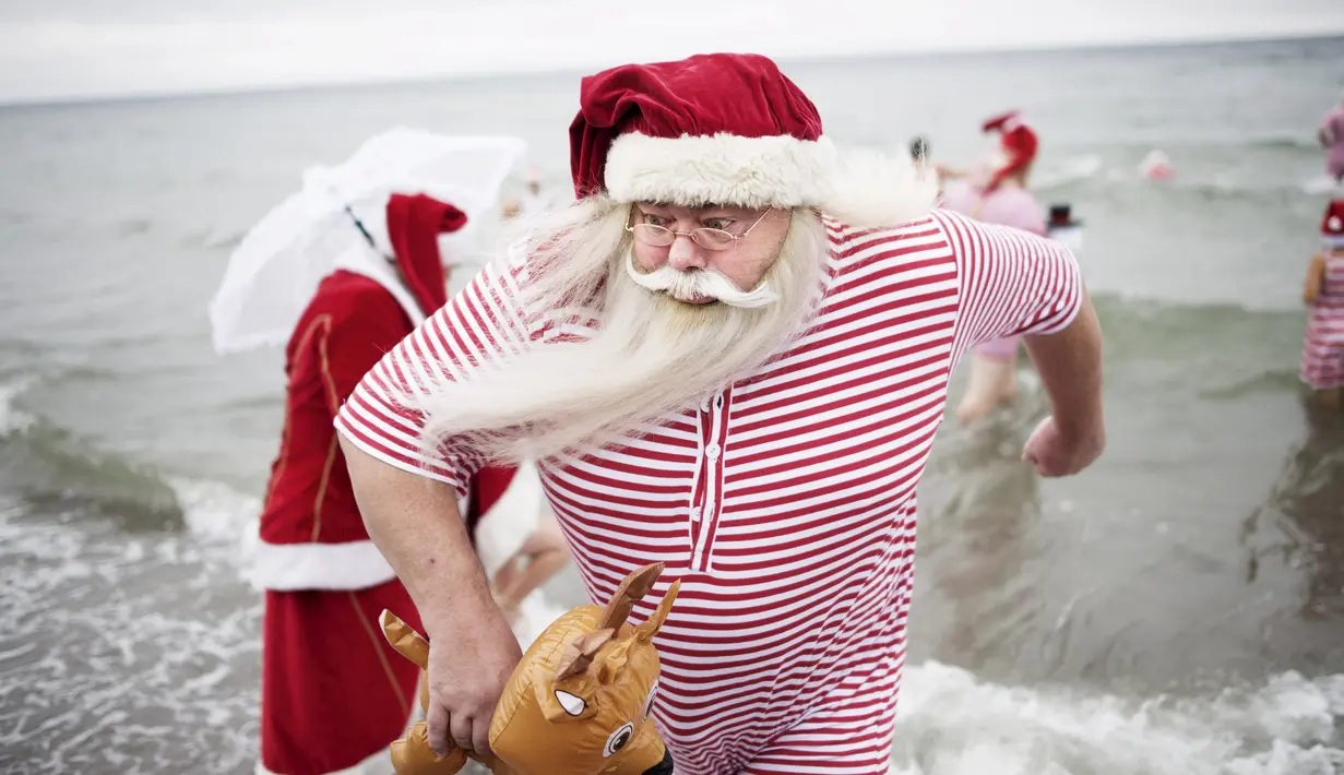 Seorang peserta Kongres Santa Claus Dunia 2015 bersiap berenang di pantai Bellevue di Copenhagen, Denmark, Minggu (21/7/2015). (REUTERS/Scanpix Denmark/Erik Refner)