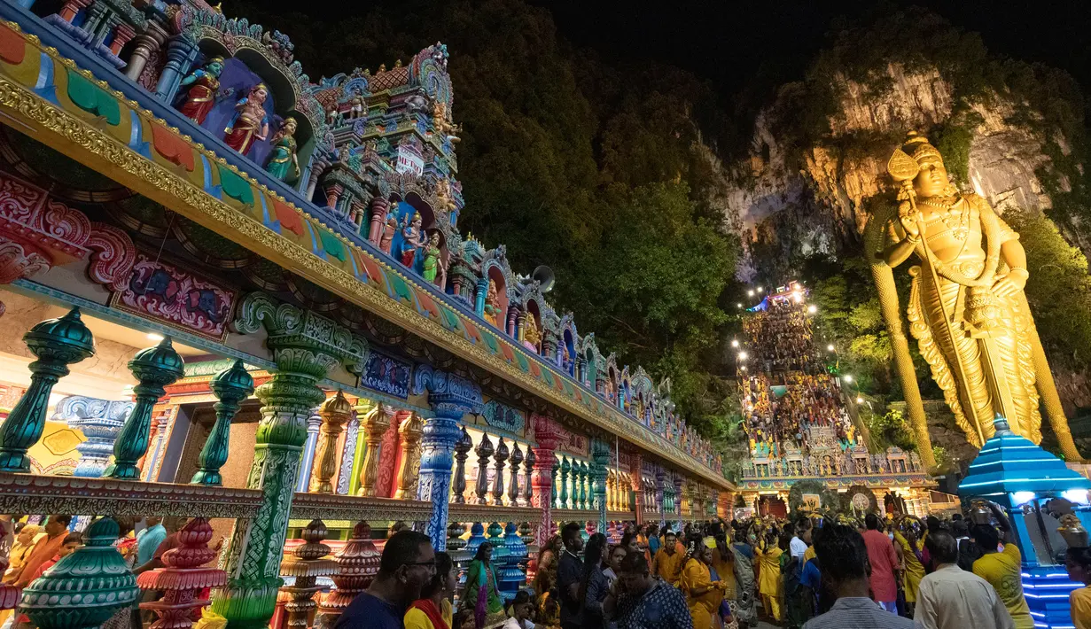 Patung raksasa Dewa Muruga berdiri di sebelah tangga menuju Kuil Batu Caves di Kuala Lumpur, Malaysia, Senin (21/1). Keramaian pengunjung terlihat saat perayaan Festival Thaipusam di lokasi tersebut. (AP Photo/ Vincent Thian)