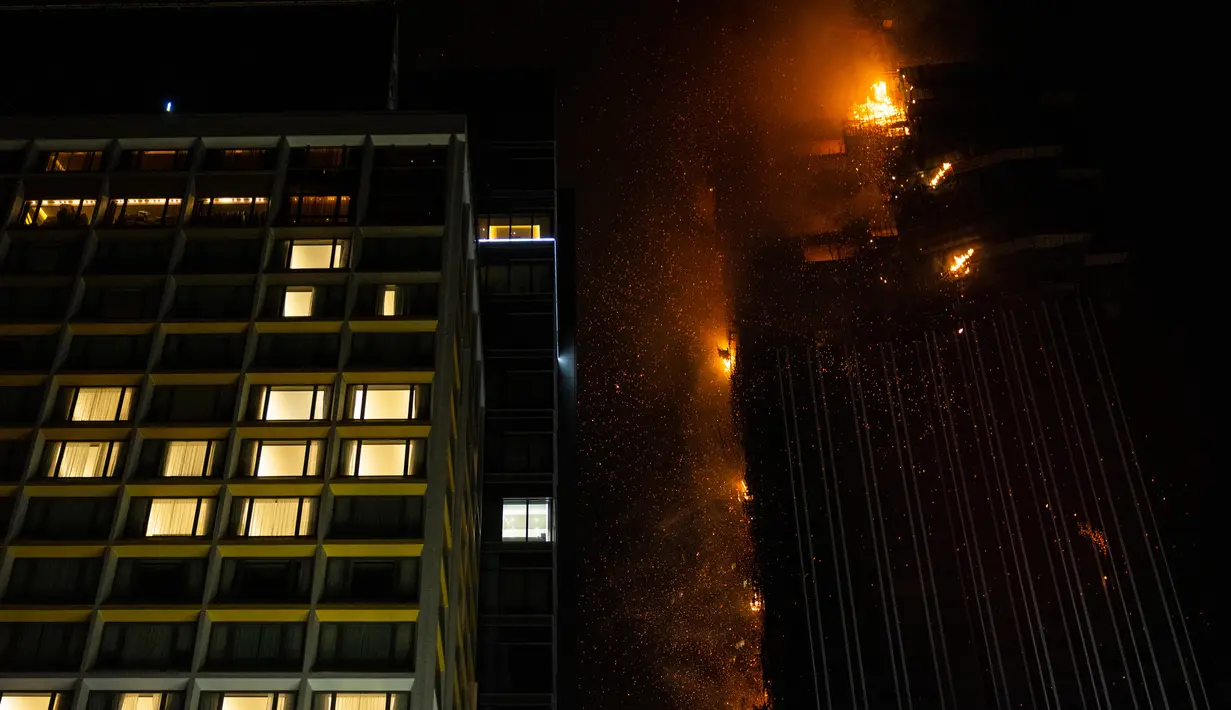 Kebakaran melanda lokasi konstruksi di Hong Kong, Jumat (3/3/2023). Media lokal mengatakan lokasi tersebut merupakan bagian dari proyek pembangunan kembali di lokasi Mariner's Club yang lama, seperti dikutip Reuters. (AP Photo/Louise Delmotte)