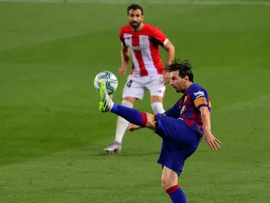Penyerang Barcelona, Lionel Messi berusaha mengontrol bola saat bertanding melawan Athletic Bilbao pada lanjutan La Liga Spanyol di stadion Camp Nou, Barcelona (23/6/2020). Barcelona menang tipis atas Bilbao 1-0 berkat gol tunggal Ivan Rakitic. (AFP/Pau Barrena)