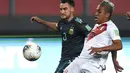 Gelandang Peru, Christian Cueva berebut bola dengan pemain Argentina, Nicolás Tagliafico pada pertandingan kualifikasi Piala Dunia 2022 di Lima, Peru, Selasa (17/11/2020). Argentina menang 2-0 atas Peru. (Ernesto Benavides, Pool via AP)