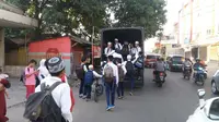 Warga baik tua maupun muda senang saat diangkut kendaraan yang disopiri polisi Cirebon meski duduk berdesakan, bahkan sebagian berdiri. (Liputan6.com/Panji Prayitno)
