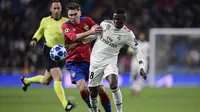 Bek CSKA Moskow, Kirill Nababkin, berebut bola dengan striker Real Madrid, Vinicius Junior, pada laga Liga Champions di Stadion Santiago Bernabeu, Madrid, Rabu (12/12). Madrid kalah 0-3 dari CSKA. (AFP/Javier Soriano)