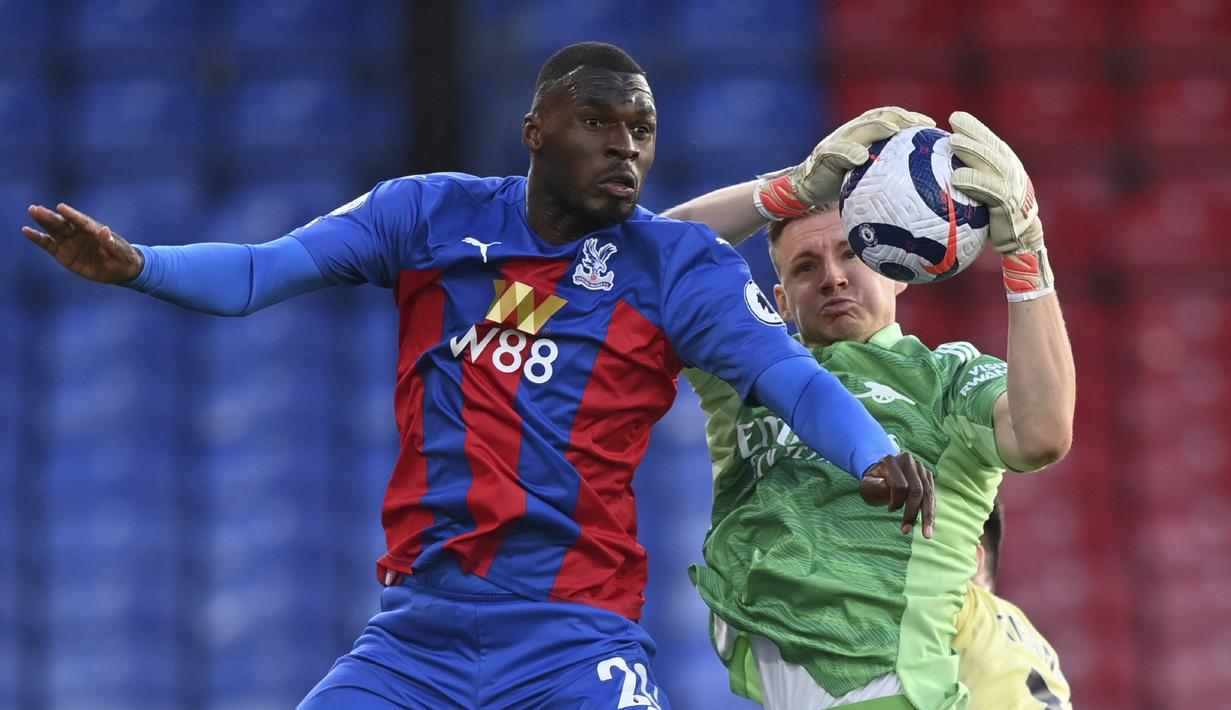 Kiper Arsenal, Arsenal Bernd Leno merebut bola dibayangi penyerang Crystal Palace, Christian Benteke pada pekan ke-37 Liga Inggris, Kamis (20/5/2021) dini hari WIB. The Gunners -julukan Arsenal- menang dengan skor 3-1 di markas Crystal Palace. (Justin Setterfield/Pool Photo via AP)