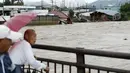 Warga menyaksikan banjir dari Sungai Kinugawa yang menerjang rumah-rumah di Joso, prefektur Ibaraki, Jepang, Kamis (10/9). Satu orang hilang dan lebih dari 90 ribu warga diperintahkan untuk mengungsi. (REUTERS/Kyodo)