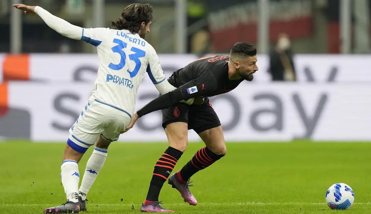 Bek Empoli Sebastiano Luperto berebut bola dengan penyerang AC Milan Olivier Giroud (kanan) pada pekan ke-29 Liga Italia di Stadion San Siro, Minggu (13/3/2022) dini hari WIB.  AC Milan menang tipis 1-0 atas tamunya, Empoli. (AP Photo/Antonio Calanni)