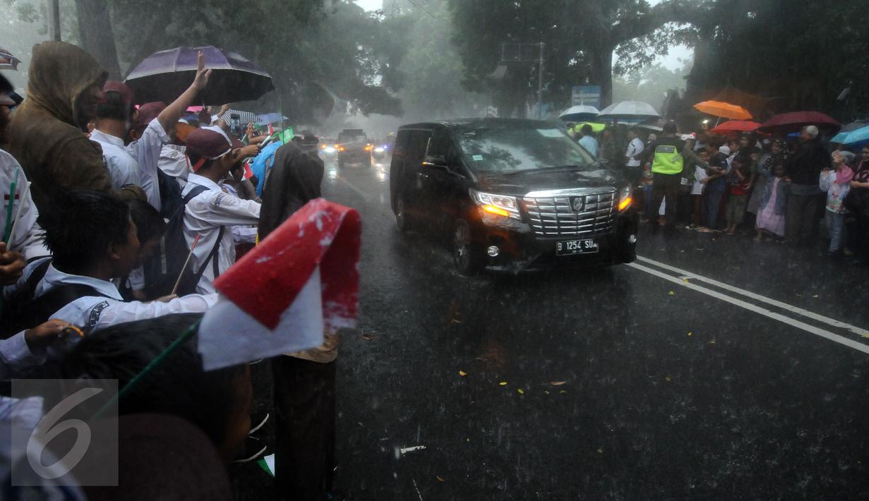 Pelajar dan warga menyambut kedatangan mobil delegasi di sekitar Istana Bogor, Rabu (1/3). Kedatangan Raja Salman bin Abdulaziz ke Istana Bogor disambut puluhan ribu pelajar dan warga. (Liputan6.com/Helmi Fithriansyah) 
