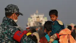Pengungsi Rohingya naik kapal Angkatan Laut Bangladesh saat mereka dipindahkan ke pulau rawan banjir yang kontroversial, Bhashan Char di Teluk Benggala, di Chittagong (29/12/2020). Sebanyak 1.804 pengungsi direlokasi menggunakan tujuh kapal ke Bhasan Char. (AFP/Rehman Asad)