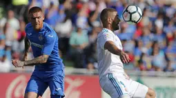 Striker Real Madrid, Karim Benzema, mengontrol bola saat pertandingan melawan Getafe pada laga La Liga Spanyol Stadion Coliseum Alfonso Perez, Sabtu (14/10/2017). Real Madrid menang 2-1 atas Getafe. (AP/Paul White)