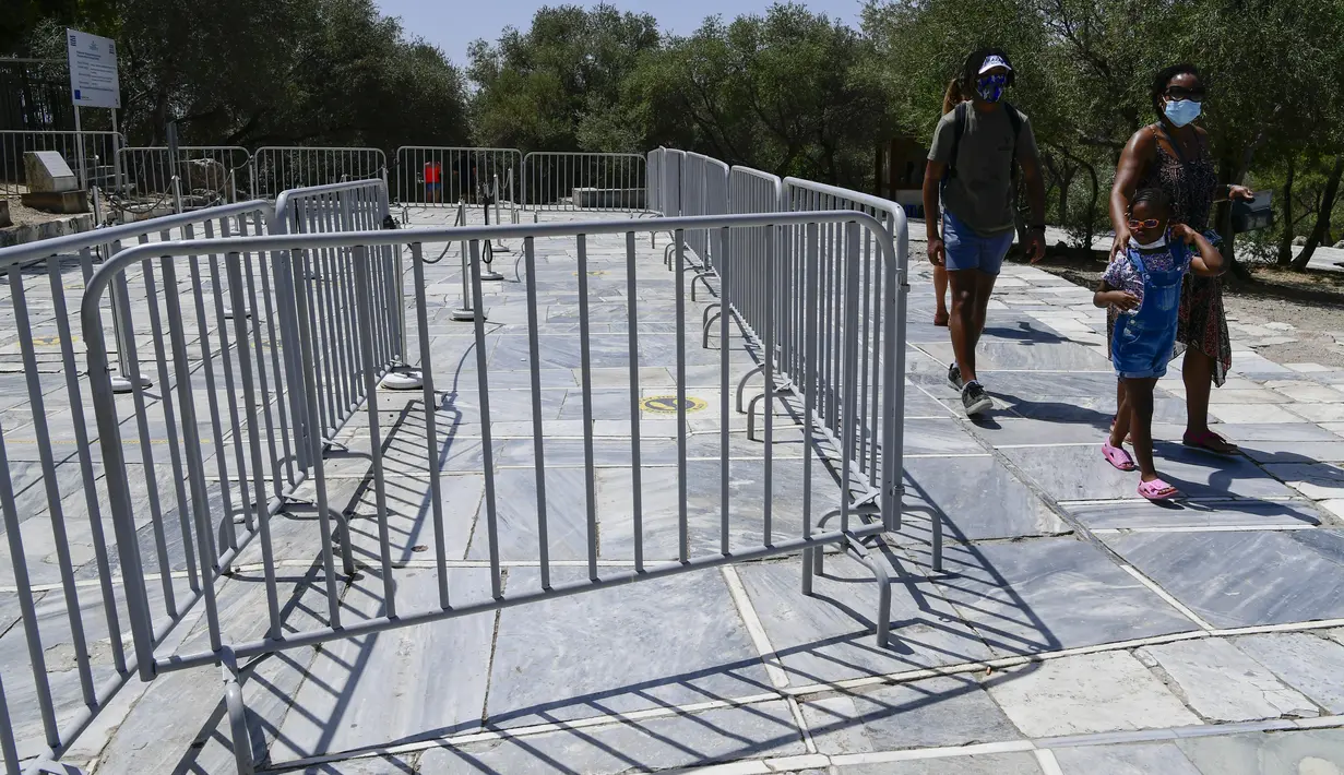 Turis keluar dari Acropolis kuno, di Athena Yunani, Selasa (3/8/2021). Pihak berwenang di Yunani telah menutup Acropolis dan situs kuno lainnya karena gelombang panas yang membakar Mediterania timur terus memburuk. (AP Photo/Michael Varaklas)