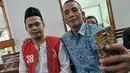 Feriyanto (kiri) berselfie saat akan mengikuti sidang perdana di Pengadilan Negeri Jakarta Selatan, (23/6). Jaksa Penuntut Umum (JPU) menilai Feriyanto telah melakukan provokasi sopir taksi se-Jabodetabek via media sosial. (Liputan6.com/Yoppy Renato)