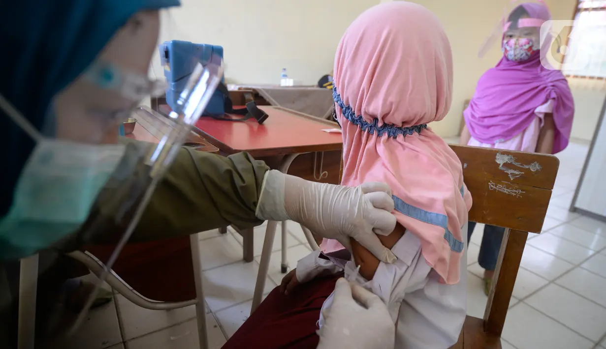 Seorang siswa kelas I mendapatkan imunisasi campak saat pelaksanaan Bulan Imunisasi Anak Sekolah (BIAS) di SDN Serua 3, Ciputat, Tangsel, Selasa (1/9/2020). Kegiatan itu untuk memberikan kekebalan terhadap siswa dari penyakit campak, difteri dan tetanus. (merdeka.com/Dwi Narwoko)