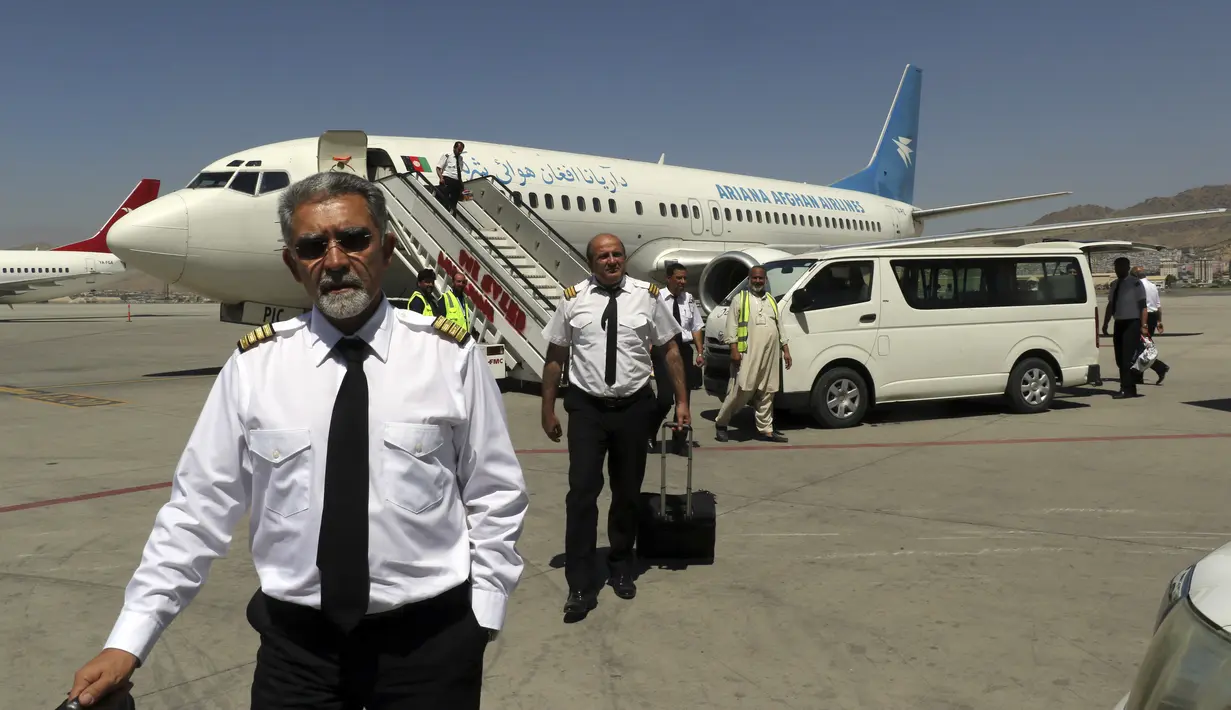 Pilot Ariana Afghan Airlines berjalan di landasan setelah mendarat di Bandara Internasional Hamid Karzai di Kabul, Afghanistan, Minggu (5/9/2021). Bandara tersebut kembali dibuka untuk penerbangan domestik. (AP/Wali Sabawoon)