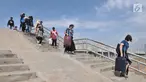 Wisatawan melintasi tangga tanggul laut yang telah selesai dibangun di Pelabuhan Kali Adem, Muara Angke, Jakarta, Selasa (12/2). Pembangunan tanggul laut tersebut memiliki tinggi 4 meter. (Merdeka.com/Iqbal S. Nugroho)