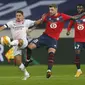 Gelandang AC Milan, Ismael Bennacer (kiri) berebut bola dengan pemain Lille, Xeka pada pertandingan lanjutan Grup H Liga Europa di stadion Stade Pierre Mauroy di Villeneuve d'Ascq, Prancis, Kamis (26/11/2020). AC Milan bermain imbang 1-1 atas Lille. (AP Photo/Michel Spingler)