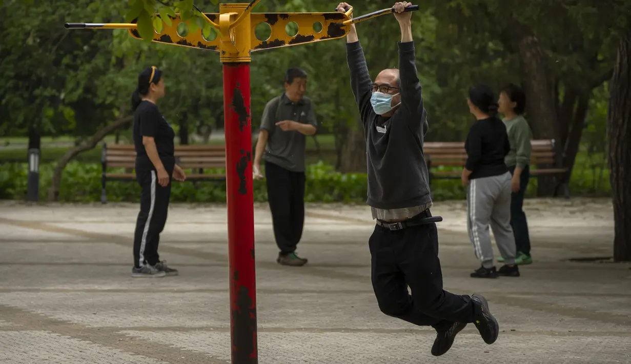 <p>Seorang pria yang mengenakan masker berolahraga di taman umum di Beijing, Kamis (21/4/2022). Di daratan Cina, jumlah kematian meningkat menjadi lebih dari 20 dalam wabah di Shanghai yang menutup kota terbesar di negara itu. (AP Photo/Mark Schiefelbein)</p>