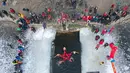 Foto udara yang diambil pada 25 Januari 2022 ini menunjukkan penggemar renang musim dingin menunjukkan bintang yang dibentuk dengan garis merah saat mereka berenang di danau yang sebagian beku di Shenyang, di provinsi Liaoning, China timur laut. (STR/AFP)