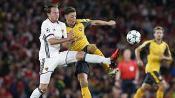 Pemain Basel, Luca Zuffi (kiri) berusaha menghadang sepakan Mesut Ozil pada laga grup A Liga Champions di Emirates stadium, London, Kamis (29/9/2016)dini hari WIB. (AP/Alastair Grant)