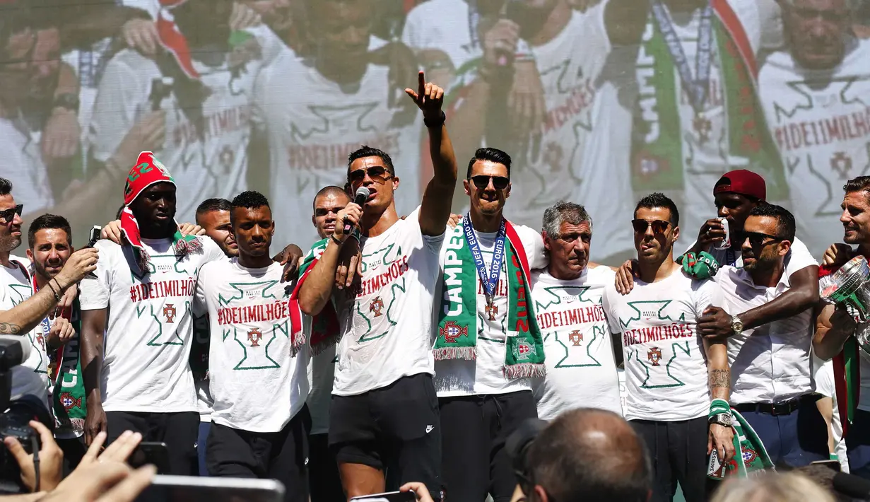 Cristiano Ronaldo dan tim kesebelasan menyapa pendukung mereka di atas bus terbuka saat kembali ke Lisbon, Portugal, Senin (11/7). Portugal menjadi juara Piala Eropa 2016 usai mengalahkan Prancis di final. (REUTERS / Pedro Nunes)