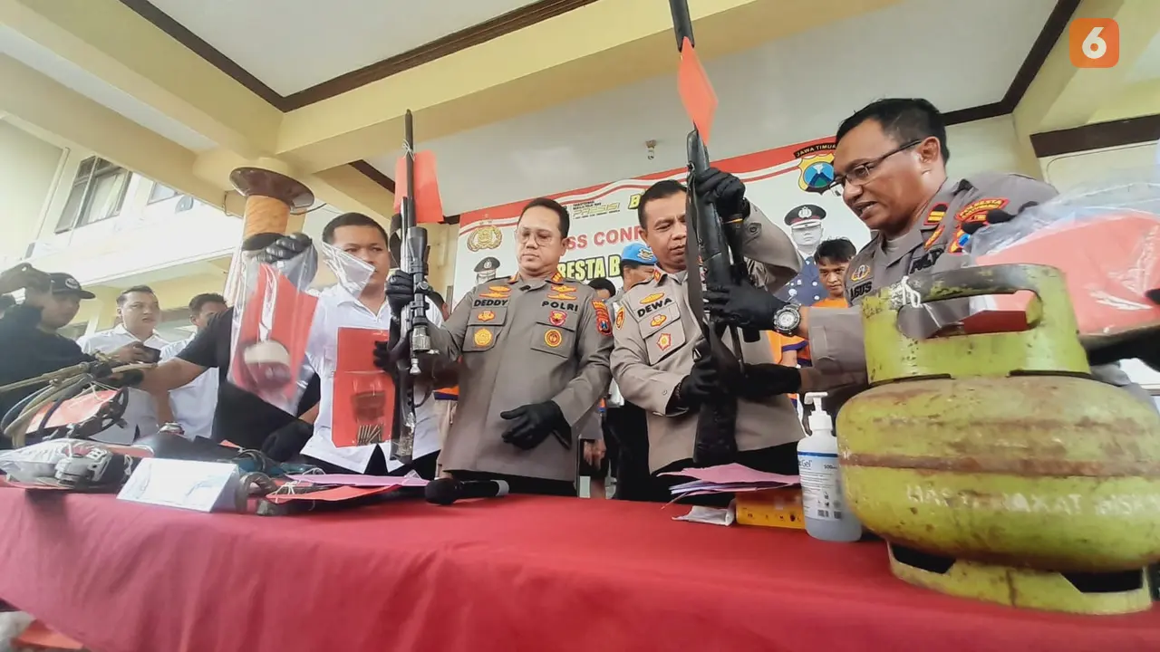 Kapolresta Banyuwangi Kombespol Deddy Foury Millewa (Tengah) menunjukan senpi rakitan yang disita dari tangan para tersangka (Hermawan Arifianto/Liputan6.com)
