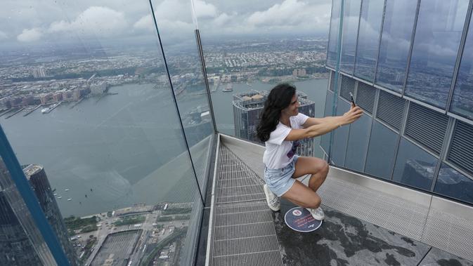 Pengunjung berswafoto dari Edge, dek langit tertinggi di luar ruangan di Western Hemisphere saat dibuka kembali untuk umum di New York, Rabu (2/9/2020). Dek pengamatan tertinggi di belahan bumi bagian barat itu menawarkan pemandangan 360 derajat langit ikonik kota New York (TIMOTHY A. CLARY/AFP)