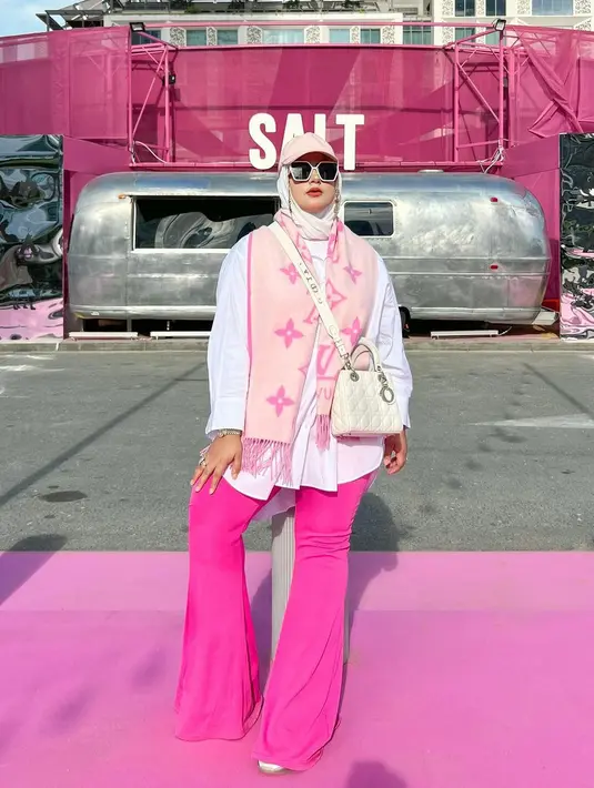 Liburan di Dubai, Tasyi tampil playful dengan padu padan kemeja putih, cutbray pants fuschia, dan syal Louis Vuitton. Ia melengkapi gayanya dengan tas Dior. [Foto: IG/tasyiiathasyia].