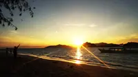 Mengabadikan matahari terbit menjadi salah satu favorit pencinta swafoto di pantai pasir putih Pulau Saronde, Kabupaten Gorontalo Utara, Gorontalo. (Liputan6.com/Aldiansyah Mochammad Fachrurrozy)