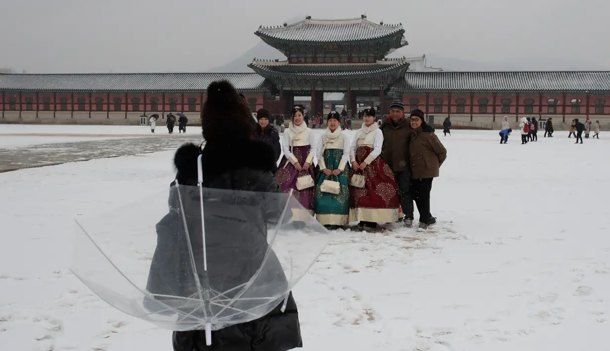 Pengunjung foto bersama saat salju turun di Istana Gyeongbok di Seoul, Korea Selatan (15/2). Istana Gyeongbok merupakan kerajaan utama selama Dinasti Joseon dan salah satu landmark terkenal di kota tersebut. (AFP Photo/Lee Jin-man)