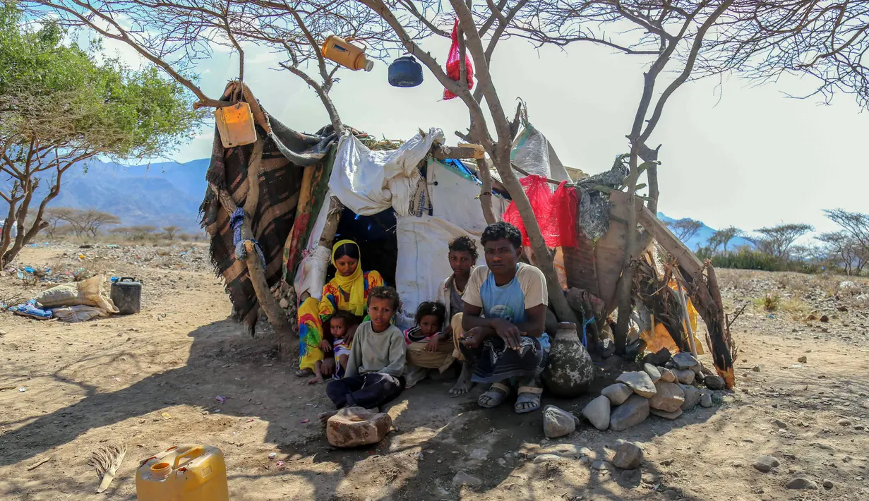 Salah satu keluarga duduk di depan gubuk mereka di kamp pengungsian Taez, Yaman (11/1). Jutaan warga melarikan diri hingga ke wilayah dataran tinggi seperti Taez. (AFP Photo/Ahmad Al-Basha)