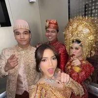 Indah memilih kebaya merah marun yang sarat akan detail artistik. Kebaya rancangan Laviena Wedding Gallery ini menghadirkan siluet klasik yang dipadu dengan sentuhan modern lewat taburan payet emas yang tertata rapi di seluruh permukaan kain. [@indahtrp].