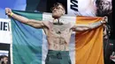 Petarung MMA, Conor McGregor, berpose dengan bendera negaranya saat sesi timbang berat badan di Las Vegas, Jumat (25/8/2017). Keduanya akan bertarung pada Minggu (27/6/2017) di T-Mobile Arena, Las Vegas, Amerika Serikat. (AP/John Locher)