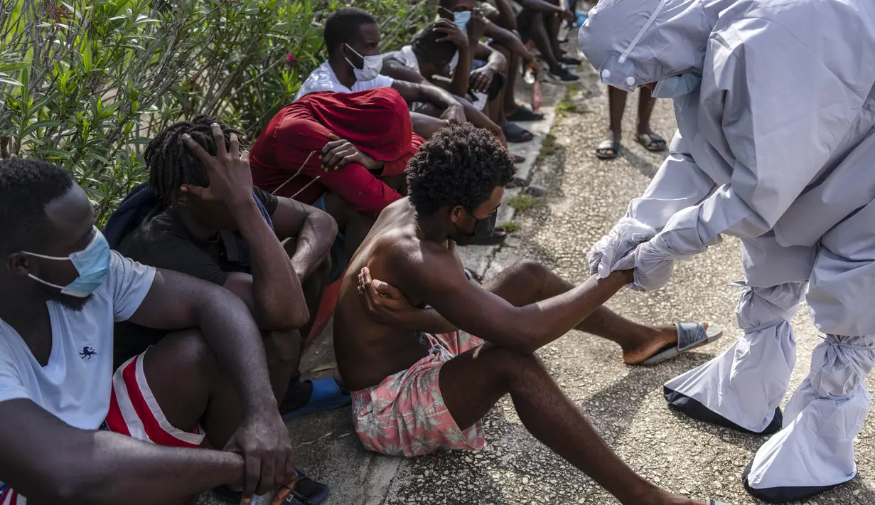 Seorang imigran Haiti dirawat dokter di sebuah perkemahan yang digunakan untuk menampung sekelompok besar migran Haiti di Sierra Morena di provinsi Villa Clara Kuba, Kamis (26/5/2022). Sebuah kapal yang membawa lebih dari 800 warga Haiti yang berusaha mencapai Amerika Serikat malah berakhir di pantai Kuba tengah. (AP Photo/Ramon Espinosa)