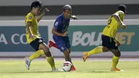 Striker Arema FC, Dendi Santoso (tengah) berusaha melewati dua pemain Barito Putera dalam laga matchday ke-2 Grup A Piala Menpora 2021 di Stadion Manahan, Solo, Kamis (25/3/2021). Arema FC sementara tertinggal 0-2 dari Barito Putera di babak pertama. (Bola.com/Arief Bagus)