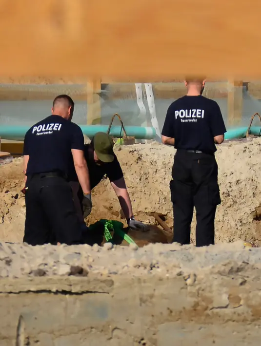 Para ahli bekerja untuk memindahkan bom perang dunia II di Berlin, Jerman, Jumat (20/4). Petugas bahkan terpaksa mengevakuasi ribuan orang dari stasiun kereta utama di kota tersebut. (dpa via AP)