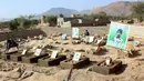 Seorang anak membersihkan makam anak-anak sekolah di sebuah pemakaman di provinsi kubu pemberontak Huthi di Saada (4/9). Anak-anak tersebut tewas terkena serangan udara koalisi pimpinan Saudi di pasar Dahyan pada bulan Agustus. (AFP Photo/Stringer)