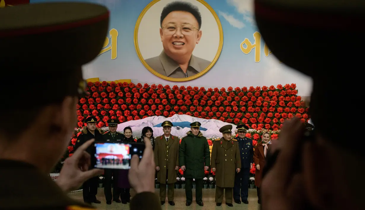 Tentara dari Rusia, Iran dan China dan Korea Utara berpose di depan pajangan selama pameran bunga 'Kimjongilia' di Pyongyang, Kamis (14/2). Korea Utara menggelar festival bunga merayakan ulang tahun mendiang ayah Kim Jong-un, Kim Jong-il.. (Ed JONES/AFP)