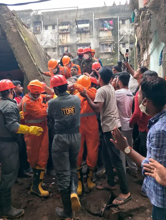 Pasukan Respons Bencana Nasional (NDRF) membawa korban selamat setelah runtuhnya bangunan tempat tinggal tiga lantai di Bhiwandi, India, Senin (21/9/2020). Sepuluh orang tewas dan puluhan lainnya masih dikhawatirkan terjebak di reruntuhan bangunan tersebut. (National Disaster Response Force via AP)