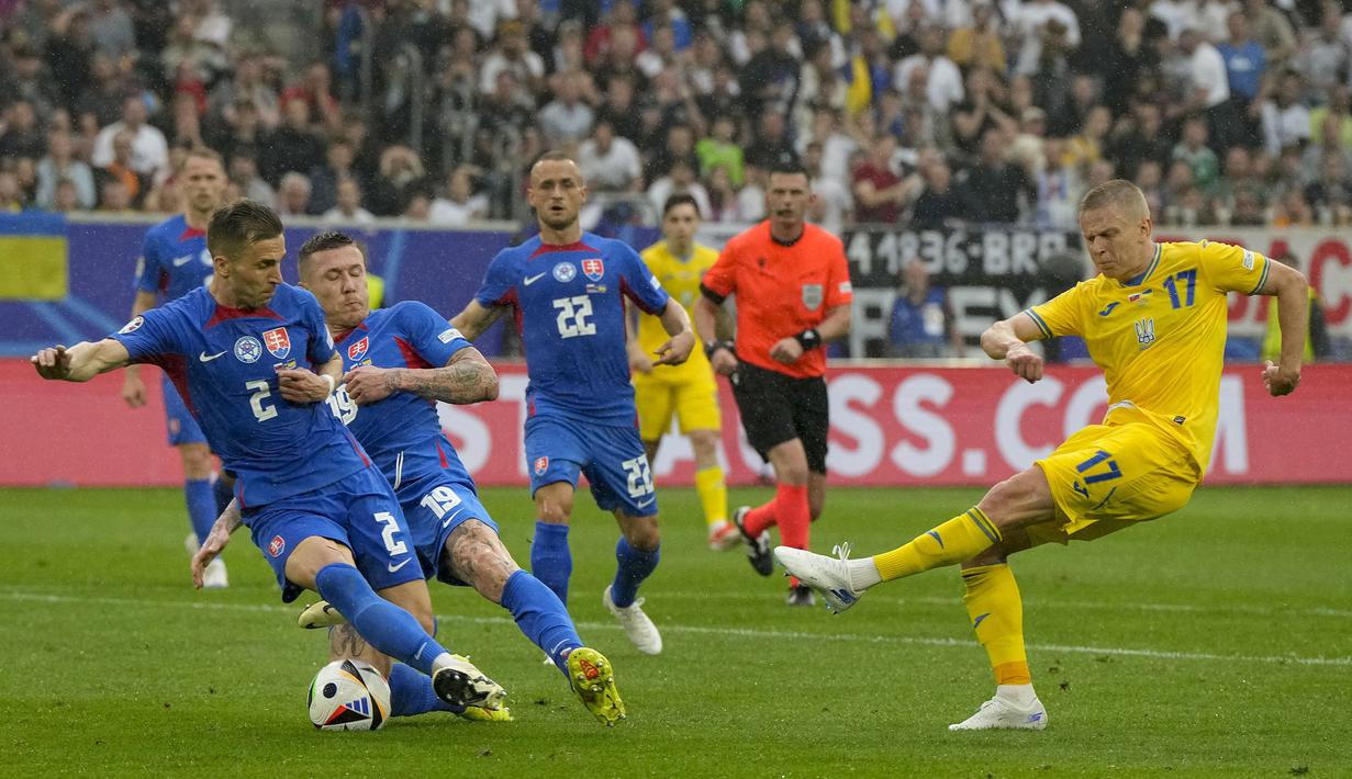 Bek Timnas Ukraina, Oleksandr Zinchenko (kanan) melepaskan tendangan dari dalam kotak penalti yang berusaha diblok dua pemain Timnas Slovakia, Juraj Kucka (tengah) dan Peter Pekarik pada laga matchday kedua Grup E Euro 2024 di Merkur Spiel-Arena, Dusseldorf, Jerman, Jumat (21/6/2024). (AP Photo/Martin Meissner)