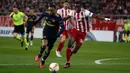 Striker Arsenal, Alexandre Lacazette mengejar bola dibyaangi pemain Olympiakos Piraeus, Ousseynou Ba pada leg pertama babak 32 besar Liga Europa di Georgios Karaiskakis Stadium, Kamis (20/2/2020). Lacazette membawa Arsenal meraih kemenangan atas tuan rumah Olympiacos 1-0. (AP/Thanassis Stavrakis)