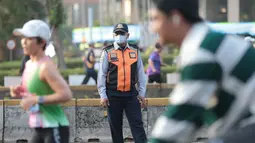 Petugas Dinas Perhubungan (Dishub) memantau aktivitas warga yang mengikuti Car Free Day (CFD) Jakarta dengan mengenakan masker di tengah sebaran abu vulkanik. (KLY/Budy Santoso)