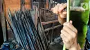 Sejumlah bambu yang digunakan untuk pengasapan ikan atau ayam di Setu Tujuh Muara Sawangan, Depok, Minggu (19/06/2022). Pengasapan ikan dengan menancapkan bambu diatas bara api ini memakan waktu sekitar 7 jam dijual dengan harga Rp85.000 per kilogram. (Liputan6.com/Fery Pradolo)