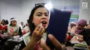 Seorang pengemudi ojek online wanita memoleskan lipstik saat kelas kecantikan jelang peragaan busana di Rawamangun, Jakarta, Jumat (20/4). Kegiatan digelar menyambut Hari Kartini yang jatuh pada 21 April mendatang. (Liputan6.com/Fery Pradolo)