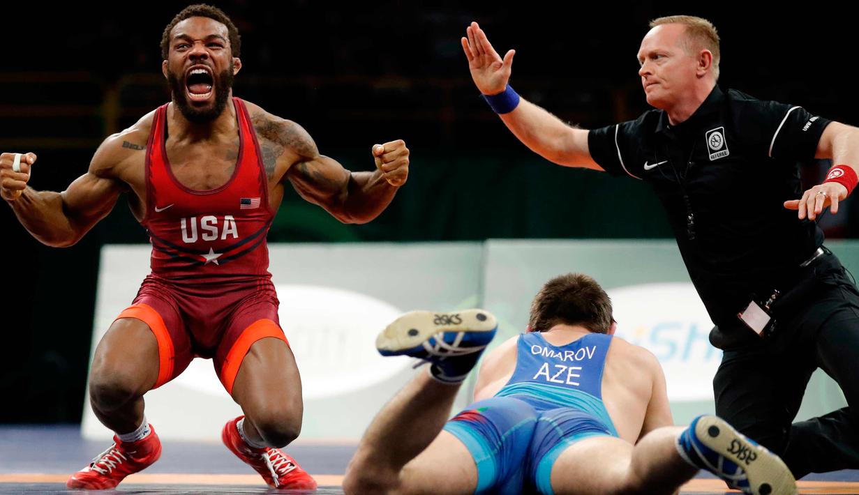 Burroughs Jordan dari AS (kiri) merayakan kemenangan usai mengalahkan Gasjimurad Omarov dari Azerbaijan dalam pertandingan gulat 74 kilogram di Freestyle Wrestling World Cup di Iowa City, Iowa (8/4). (AP Photo/Charlie Neibergall)