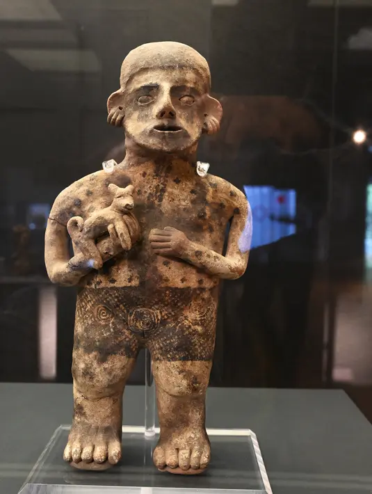 Patung Mesoamerika dari tradisi makam poros yang berasal dari 300 AC hingga 600 DC dipamerkan di Pusat Kebudayaan Universitas Tlatelolco di Mexico City (8/12/2021). (AFP/Rodrigo Arangua)