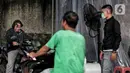 Pengendara sepeda motor disemprot cairan disinfektan saat akan memasuki pemukiman warga di kawasan H. Gari, Pesanggrahan, Jakarta, Jumat (3/4/2020). Penyemprotan secara swadaya tersebut dilakukan warga untuk mencegah penyebaran virus corona COVID-19. (Liputan6.com/Johan Tallo)